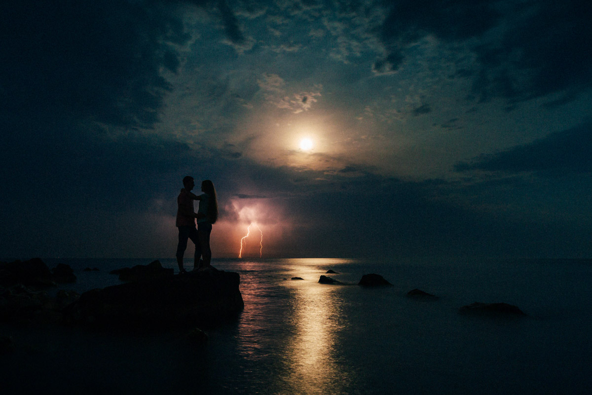 Фото пары на фоне молнии и моря в полнолуние
